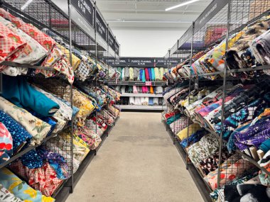 Rockford, Illinois - 19 Mart 2025: Tasfiye aşamasındaki JoAnn Fabrika mağazasında kumaş seçimi