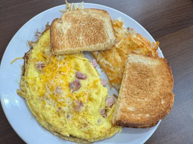 Jambon ve peynirli omlet, tost ve hashbrowns ile nefis bir kahvaltı.