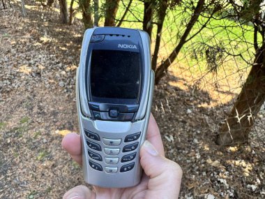 Minneapolis, Minnesota - 27 Nisan 2025: Hand, uzatılmış klavyeli klasik bir Nokia 6800 kapaklı telefon tutuyor. Telefon 2003 'ten.
