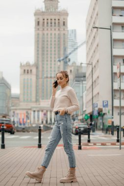 Polonya 'nın Varşova şehrinde cep telefonu kullanan genç bir kadın..