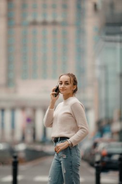 Polonya 'nın Varşova şehrinde cep telefonu kullanan genç bir kadın..