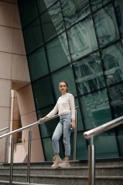 Varşova şehrindeki ünlü sanat dağının merdivenlerinde yürüyen genç bir kadın. Varşova 'daki konser evinin yakınındaki merdivenlerde yürüyen genç bir turist kadın..