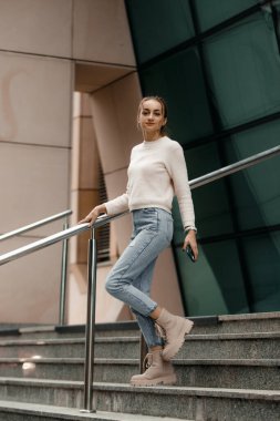 Varşova şehrindeki ünlü sanat dağının merdivenlerinde yürüyen genç bir kadın. Varşova 'daki konser evinin yakınındaki merdivenlerde yürüyen genç bir turist kadın..