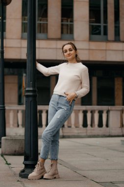 Lamba direğinin yanında poz veren genç bir kız. Varşova.