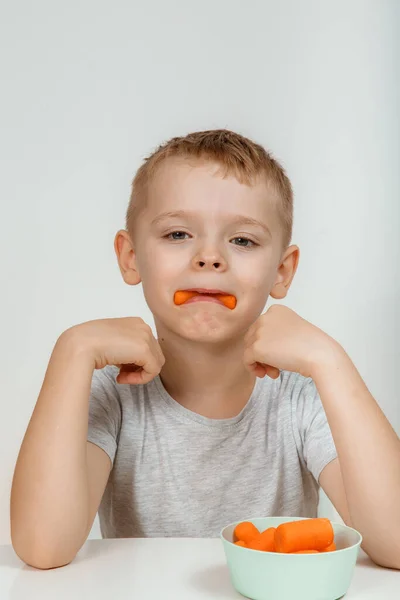 小さな男の子 白に隔離されたニンジンをかむ 学習の概念 良いビジョン — ストック写真
