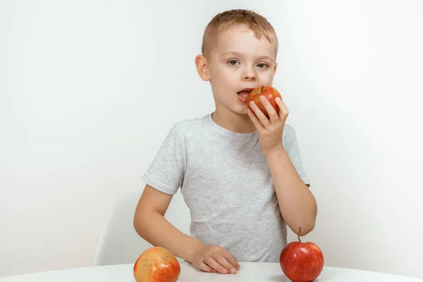 男の子はリンゴ 健康的な食べ物やビタミン 白い背景 柔らかい焦点を保持しています 孤立した白い背景に赤いリンゴを持つ楽しい少年 — ストック写真