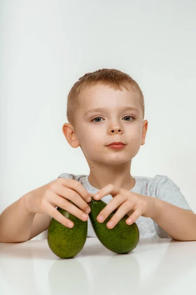 stock image Healthy food and vegetarianism. Boy Showing Avocado and Thumb Up Close Up Isolated. Avocado Cut in Half. Little kid with fresh avocado on light background. High quality photo.