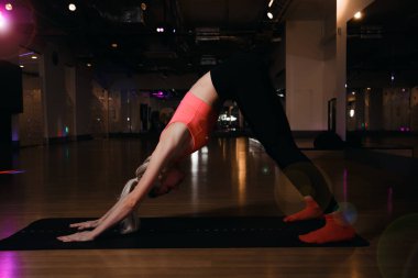 Yoga yapan genç ve çekici bir kadın. Kobra pozu veren formda bir kadın yoga minderinde, stüdyoda egzersiz yapıyor. Aşağı Bakış.