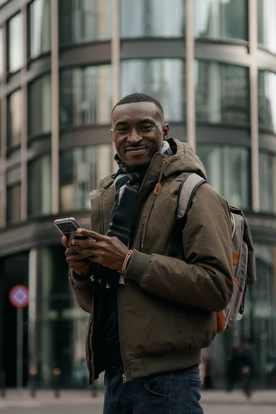 stock image Young african american using smartphone at the city. Happy african american man using mobile phone on city street. Walking outdoors, using mobile phone. Looking looking for directions in navigator.