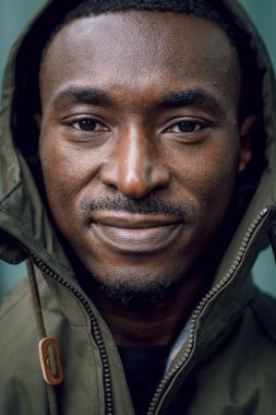 Sokakta çekici bir adam. Deri ceketli, kapüşonlu, havalı şehirli yakışıklı hippi adam duvarın yanında. Kapüşonlu rahat ceketli genç bir Afrikalı. Metin için boşluk.