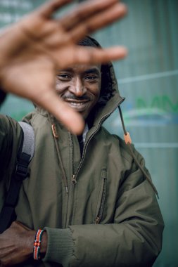 Sokakta çekici bir adam. Deri ceketli, kapüşonlu, havalı şehirli yakışıklı hippi adam duvarın yanında. Kapüşonlu rahat ceketli genç bir Afrikalı. Metin için boşluk.