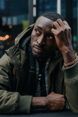 Düşünceli Afrikalı adam düşünüyor. Düşünceli genç Afrikalı adamın portresi plan, fikir, gelecek, beyin fırtınası konsepti. Genç Afro-Amerikalı bir adamın poz verirken yakın plan portresi. Nijeryalı adam.