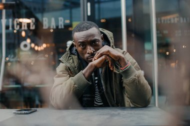 Düşünceli Afrikalı adam düşünüyor. Düşünceli genç Afrikalı adamın portresi plan, fikir, gelecek, beyin fırtınası konsepti. Genç Afro-Amerikalı bir adamın poz verirken yakın plan portresi. Nijeryalı adam.