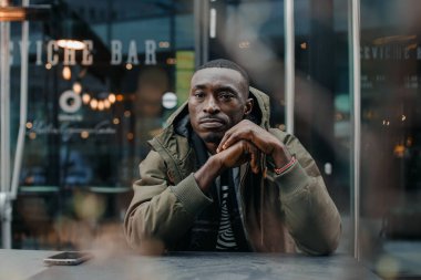 Düşünceli Afrikalı adam düşünüyor. Düşünceli genç Afrikalı adamın portresi plan, fikir, gelecek, beyin fırtınası konsepti. Genç Afro-Amerikalı bir adamın poz verirken yakın plan portresi. Nijeryalı adam.