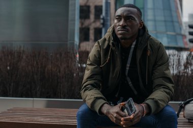 Şehir caddesinde başı ağrıyan genç bir adamın portresi. Negatif insani duygu yüz ifadesi hissi. Varşova.