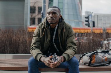 Şehir caddesinde başı ağrıyan genç bir adamın portresi. Negatif insani duygu yüz ifadesi hissi. Varşova.