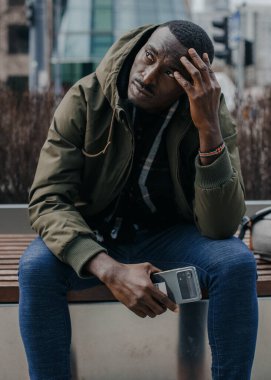 Şehir caddesinde başı ağrıyan genç bir adamın portresi. Negatif insani duygu yüz ifadesi hissi. Varşova.