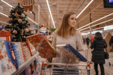 Bir yığın çikolatalı Noel Baba. Noel zamanı. Bir kadın Noel için süpermarketteki bir çocuğa hediye seçer..