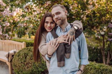 Gülümseyen dövmeli kız parkta erkek arkadaşına sarılıyor. Dövmeleri olan kızıl saçlı güzel bir kadın ve yürüyüşe çıkmış bir adam. Güzel, modaya uygun, şehir kıyafetleri içinde iki aşık sokakta öpüşüyor..