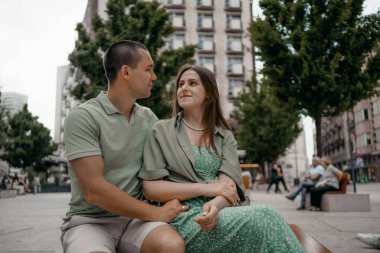 Şehirdeki bir bankta gündelik sohbetin tadını çıkaran bir çift. Varşova 'da bir bankta otururken birkaç sohbet ve gülümseme. Polonya.