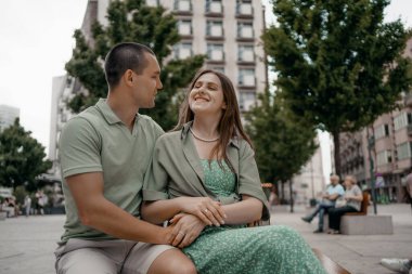 Şehirdeki bir bankta gündelik sohbetin tadını çıkaran bir çift. Varşova 'da bir bankta otururken birkaç sohbet ve gülümseme. Polonya.