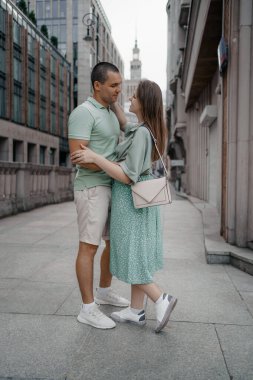 Kasabayı gezerken kucaklaşan mutlu iki turist. Polonya, Varşova 'daki kültür ve bilim sarayının önünde mutlu bir çift. Öpüşen bir çifti yakından çek..