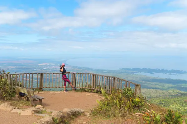Genç bir kadın telefonda konuşuyor ve mombacho volkanı açısından kameraya gülümsüyor..