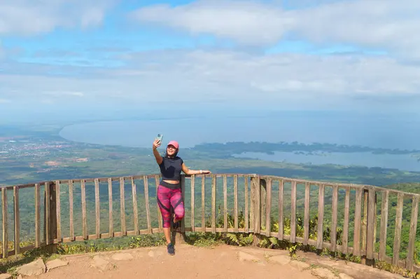 Mombacho volkanik bakış açısında gölün ve adaların arka planında selfie çeken genç bir dişi.