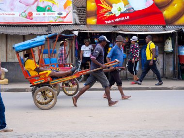 MADAGASCAR - NOVEMBER 09, 2022: Barefoot men pull rickshaws in Ansirabe, southern Madagascar. November 09.2022 Madagascar