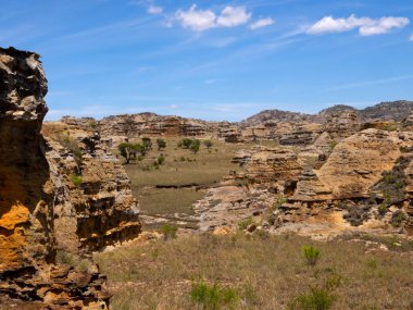 Weathered colorful rocks overgrown with vegetation in N.P Isalo. Madagascar.