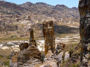 Pyramids of weathered colored rock overgrown with vegetation in N.P Isalo. Madagascar.