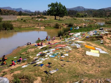 BEMARAHA, MADAGASCAR - NOVEMBER 13, 2022: Women with children wash and dry clothes by the river. 13.2022 Bemaraha, Madagascar