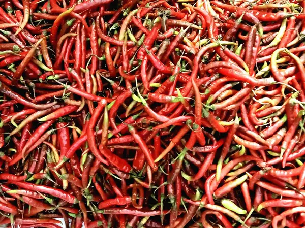 stock image red and black peppers on a market stall