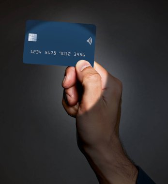 Bu resimde bir adamın elindeki bir kredi kartı gösteriliyor. Karttaki boş alan metin veya grafik bilgisi için kullanılabilir.