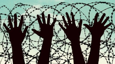 Sınır güvenliğiyle ilgili bir resimde eller ve dikenli teller görülüyor.