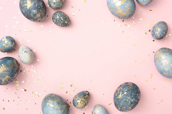 Blue Easter eggs frame, pink background with gold confetti. Chic Easter greeting card, copy space.