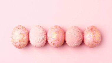 Easter eggs in row, banner, pastel pink Easter background. Monochrome greeting card, flat lay, copy space.