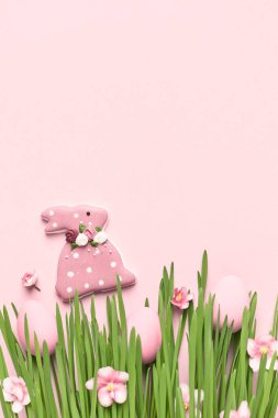 Mutlu Paskalya tebrik kartları. Pembe Paskalya yumurtaları ve tavşancık çimenlerde saklanıyor. Paskalya arkaplanı, kopyalama alanı. Yumurta avı kavramı.