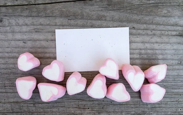 卡片和粉色棉花糖的心躺在木板上 — 图库照片