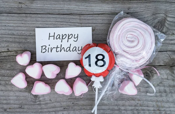幸せな18歳の誕生日の挨拶カードとピンクのマシュマロは木の板の上に横たわる — ストック写真