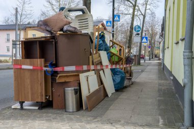 Yol kenarına mobilya ve elektrikli aletler yığılmış.