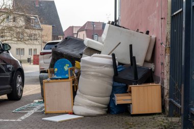 Yolun kenarında mobilya yığını var.