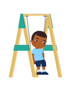 Küçük esmer tenli, üzgün yüzlü çocuk salıncakta oturuyor