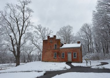 The Frazee House, a Federal-style home completed in 1827, stands within Cuyahoga Valley National Park south of Cleveland, here seen from the side amid freshly fallen snow