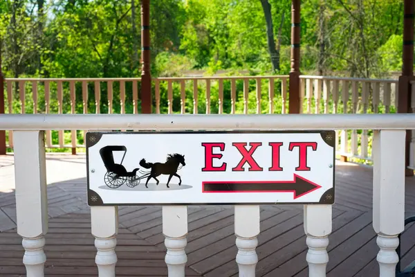 Olmsted Falls, OH, ABD - 2 Mayıs 2024: Köy çardağında at ve at arabasıyla yapılan klasik tabela, kasabanın tarihi ve antika bölgesinden çıkış yönünü gösteriyor.