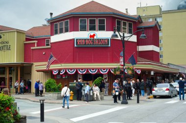 Juneau, AK, ABD - 24 Haziran 2024: Kalabalık (çoğunlukla yolcu gemilerinden), efsanevi bir tarihi olan popüler bir lokanta ve bar olan Red Dog Salonu 'nun önünde toplandı..