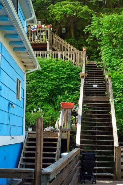 stock image Ketchikan, AK, USA - June 27, 2024: A long outdoor staircase leads to the upper deck attached to a private cottage that stands next to the Salmon Ladder viewing area on Ketchikan Creek.