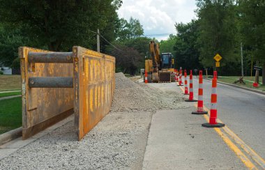 Su hattına boru döşemek için bir siper kutusu. Yol inşaatı alanında kazıcı ve yenisi.