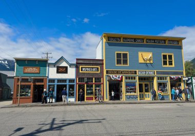 Skagway, AK, ABD - 25 Haziran 2024: Skagway 'deki Broadway Bulvarı' ndaki bir dükkan bloğunda bir yaz günü turistlere çeşitli hediyeler sunuluyor.