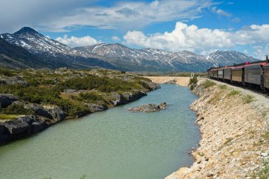 Skagway, Alaska 'dan kalkan Yukon Route demiryolu üzerinden Kanada' ya giden bir tren geri dönüş için dönüşe geçmeden önce geçitin tepesine ulaşır..